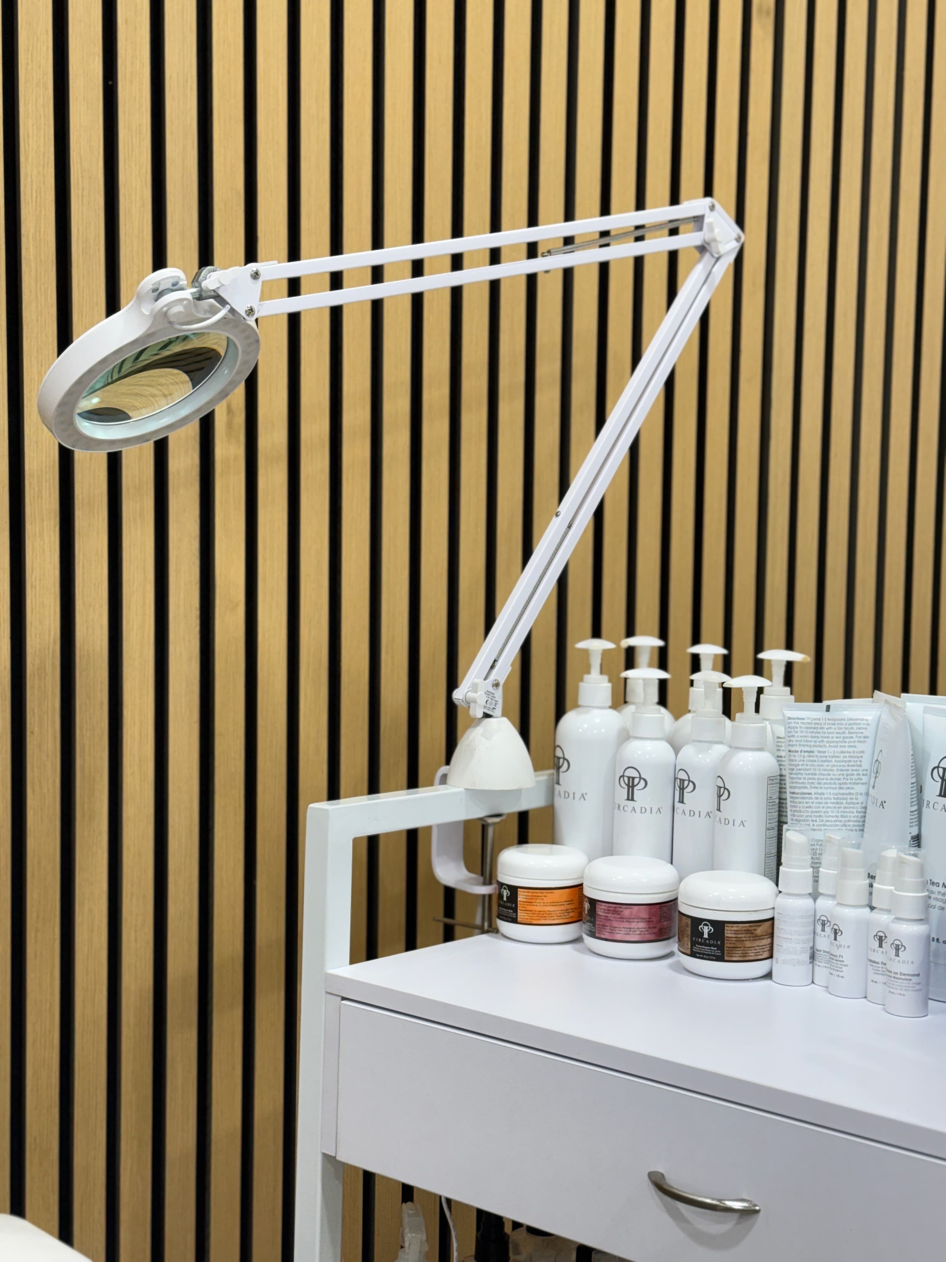 Treatment products and magnifying lamp in skin treatment room at Elixir Aesthetic, East Perth